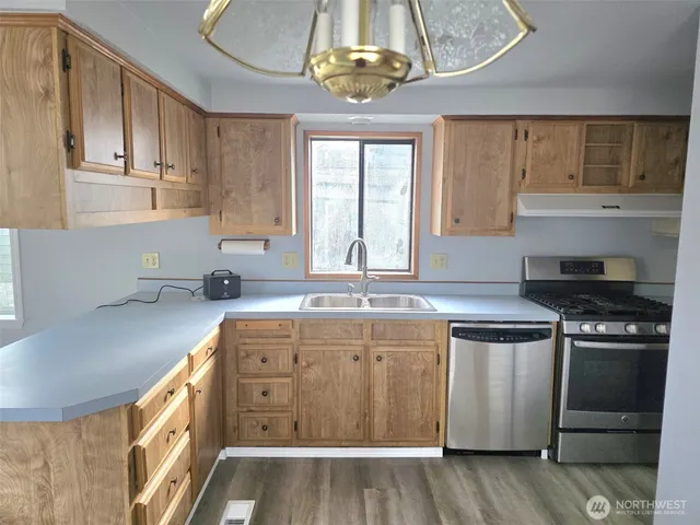 a kitchen with stainless steel appliances granite countertop a sink and cabinets