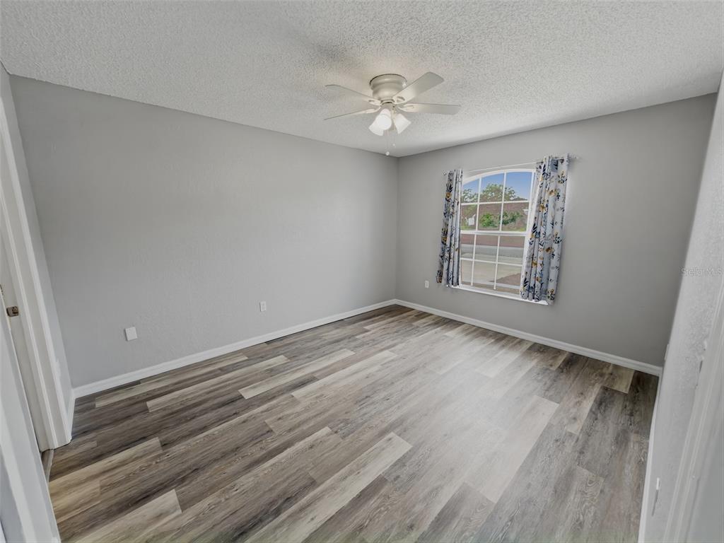 2202 Godfrey Avenue Spring Hill, FL 34609 - Photo 18 of 36 a view of an empty room with wooden floor and a window