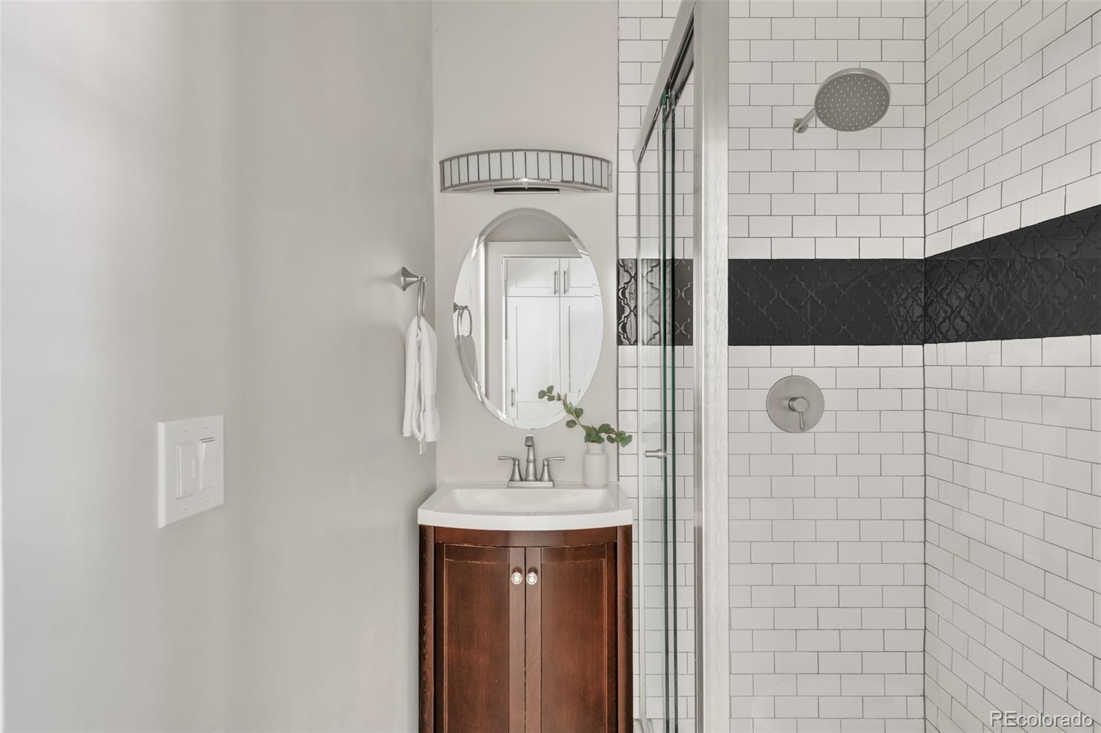 3659 Alcott Street Denver, CO 80211 - Photo 22 of 49 a bathroom with a sink a mirror and shower