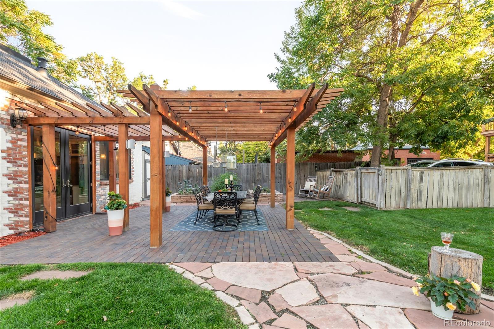 3659 Alcott Street Denver, CO 80211 - Photo 43 of 49 a view of a patio with table and chairs potted plants and large tree