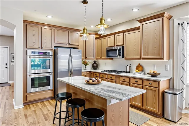a kitchen with stainless steel appliances granite countertop a stove refrigerator and cabinets