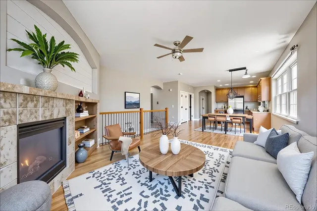 a living room with furniture a fireplace a rug and a large window