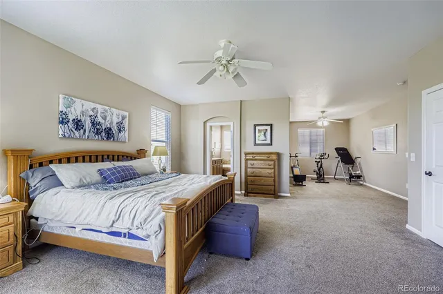 a spacious bedroom with a bed and ceiling fan