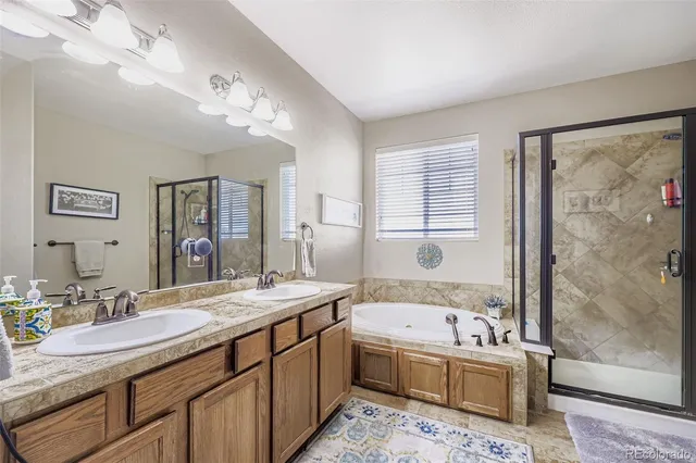 a bathroom with a granite countertop sink mirror bathtub and shower