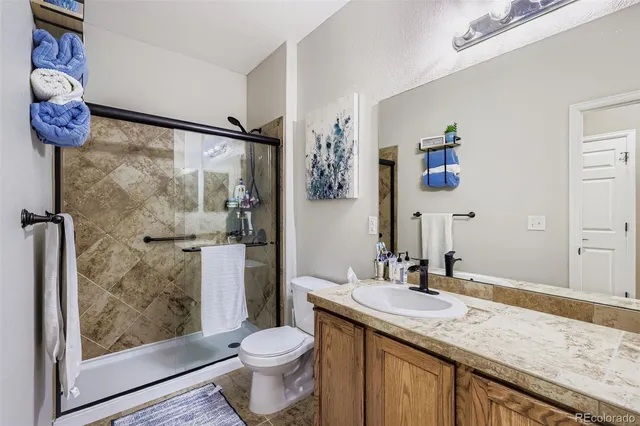 a bathroom with a granite countertop sink toilet and shower