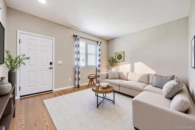 a living room with furniture and wooden floor