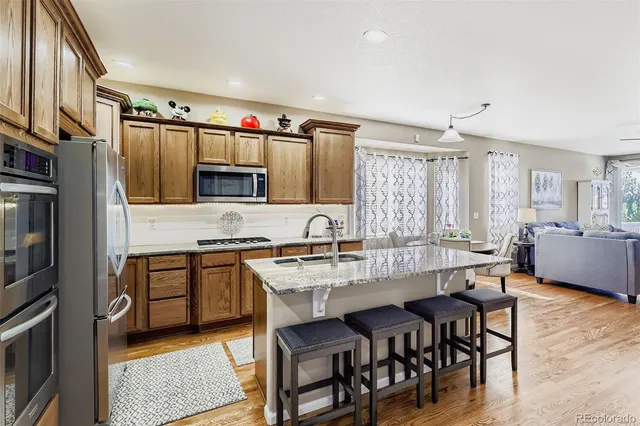 a large kitchen with granite countertop lots of counter top space and stainless steel appliances