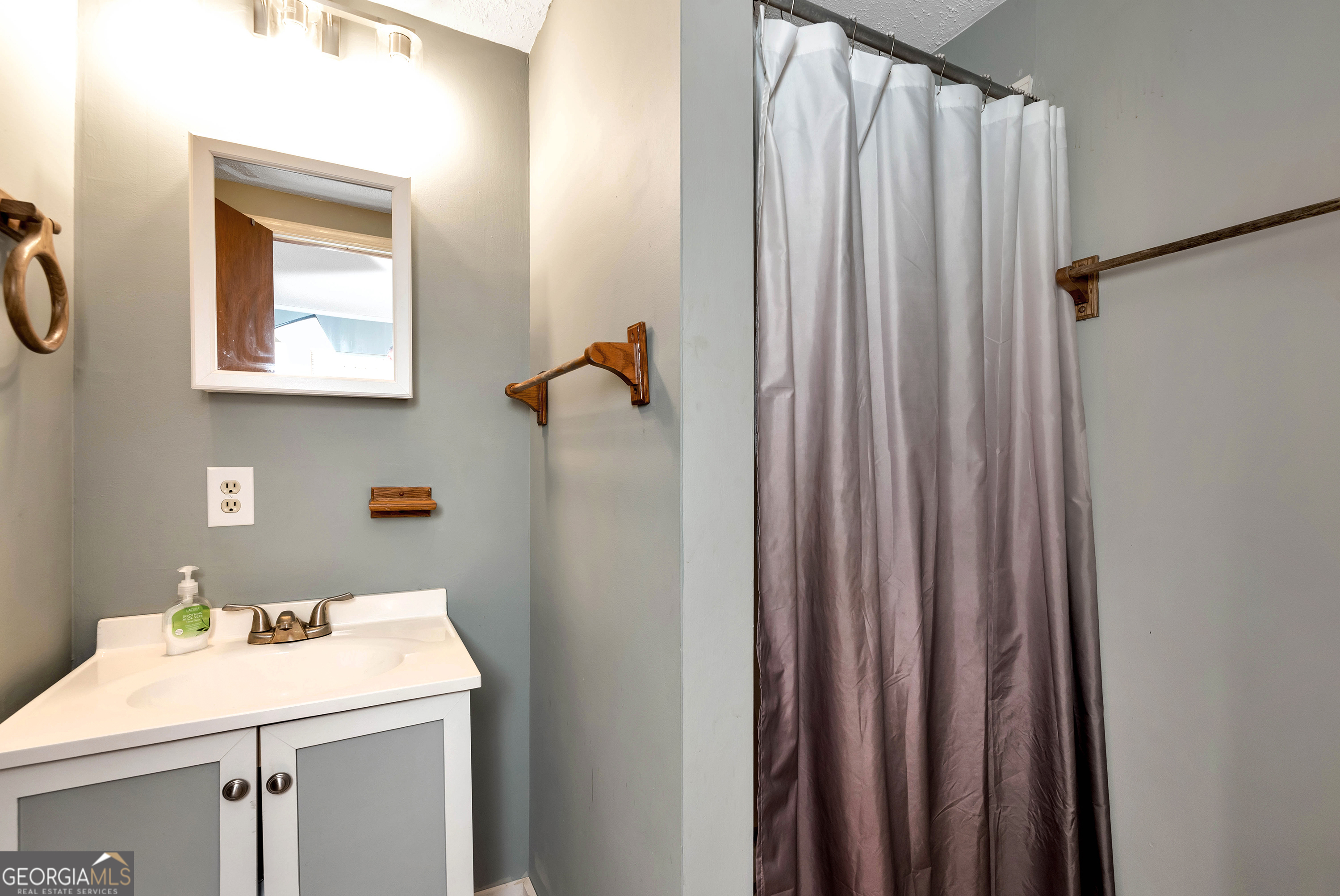373 Jennys Cove Road Cleveland, GA 30528 - Photo 12 of 44 a bathroom with a sink a mirror and a window