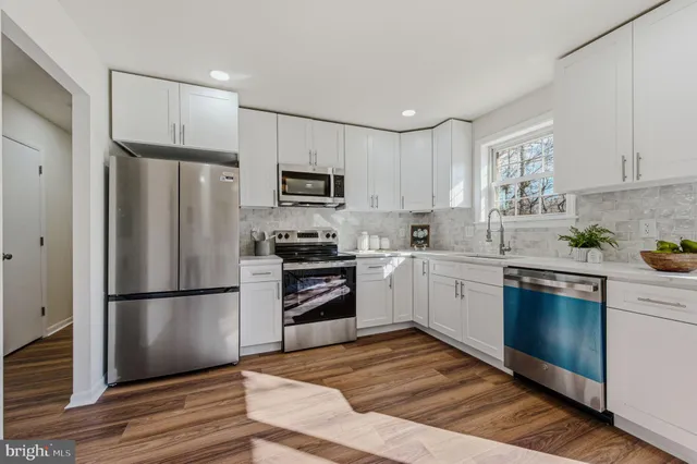 a kitchen with a refrigerator cabinets and wooden floor