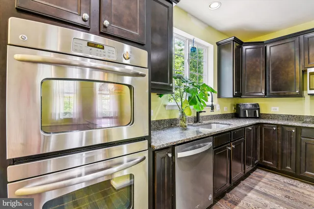 a kitchen with stainless steel appliances granite countertop a sink and a stove