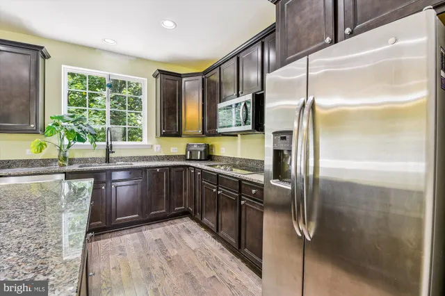 a kitchen with stainless steel appliances granite countertop a refrigerator and a sink