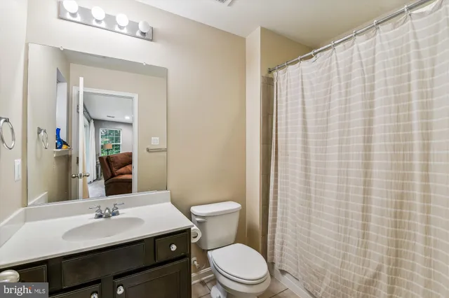 a bathroom with a sink a toilet and shower curtain