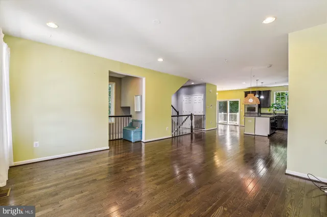 a view of a kitchen with refrigerator and wooden floor