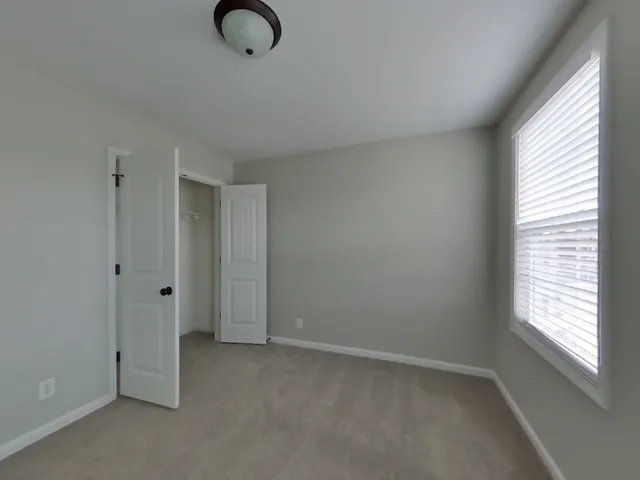 a view of an empty room with window and brick walls