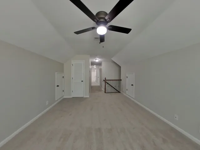 an empty room with ceiling fan and window