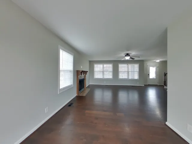 an empty room with windows and view of an empty room