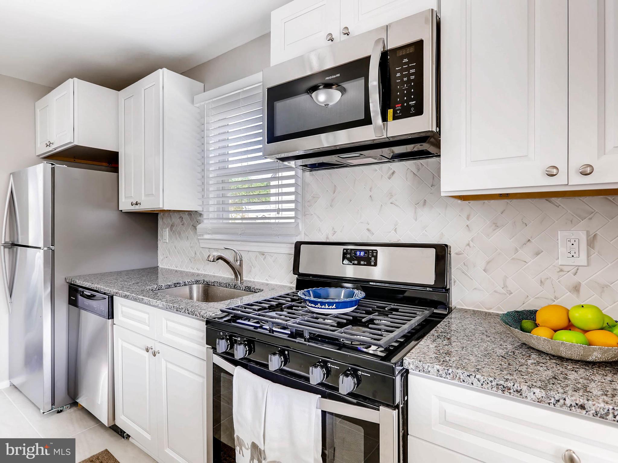 7 Forest Road Middle River, MD 21220 - Photo 7 of 27 a kitchen with stainless steel appliances granite countertop a stove a microwave and a sink