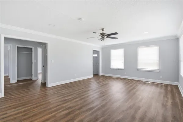 an empty room with wooden floor and windows