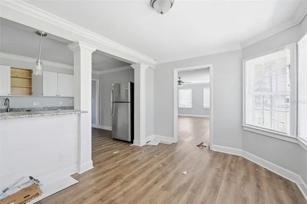 an empty room with wooden floor and windows
