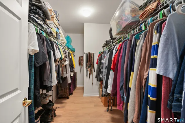 a view of walk in closet with clothes