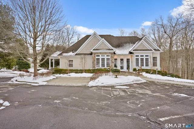 a front view of a house with a yard and large trees