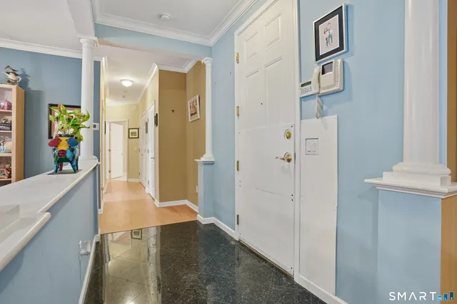 a view of a hallway with wooden floor and a living room