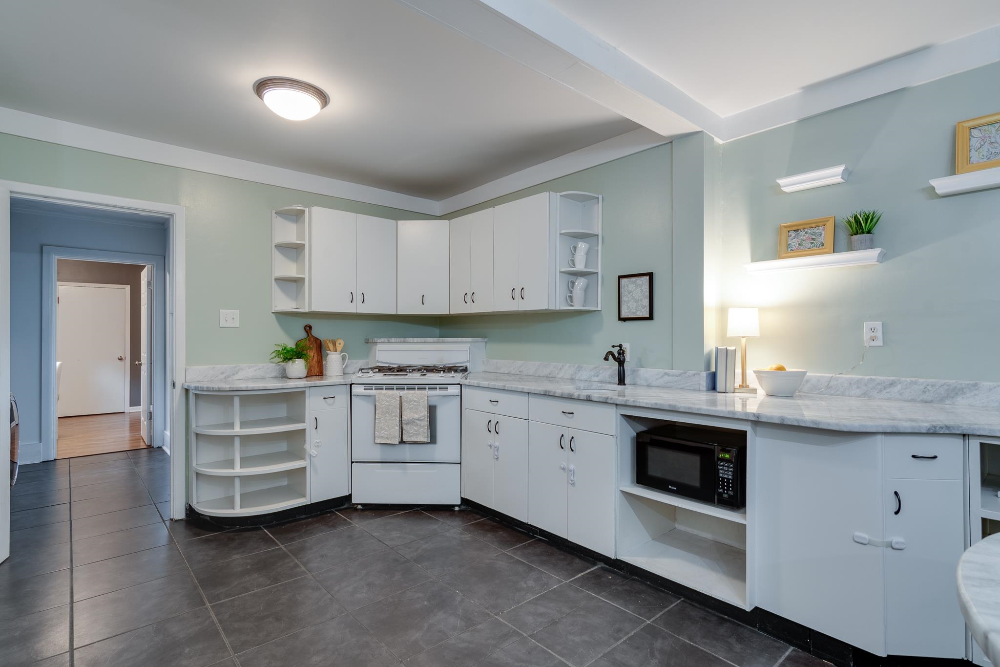 524 Alexander Street Memphis, TN 38111 - Photo 13 of 34 Kitchen featuring dark tile patterned flooring, light stone counters, gas range gas stove, and white cabinets