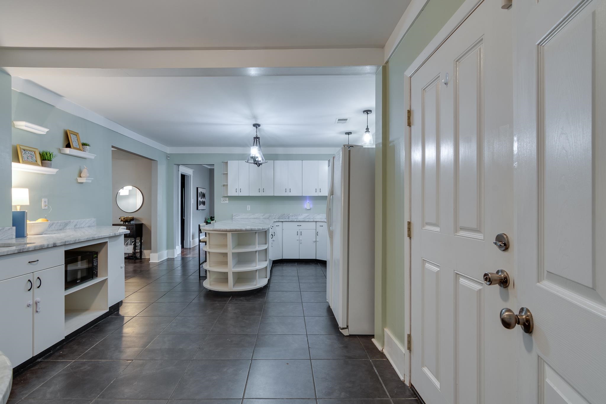 524 Alexander Street Memphis, TN 38111 - Photo 14 of 34 Kitchen with white cabinets, dark tile patterned floors, crown molding, white refrigerator with ice dispenser, and pendant lighting