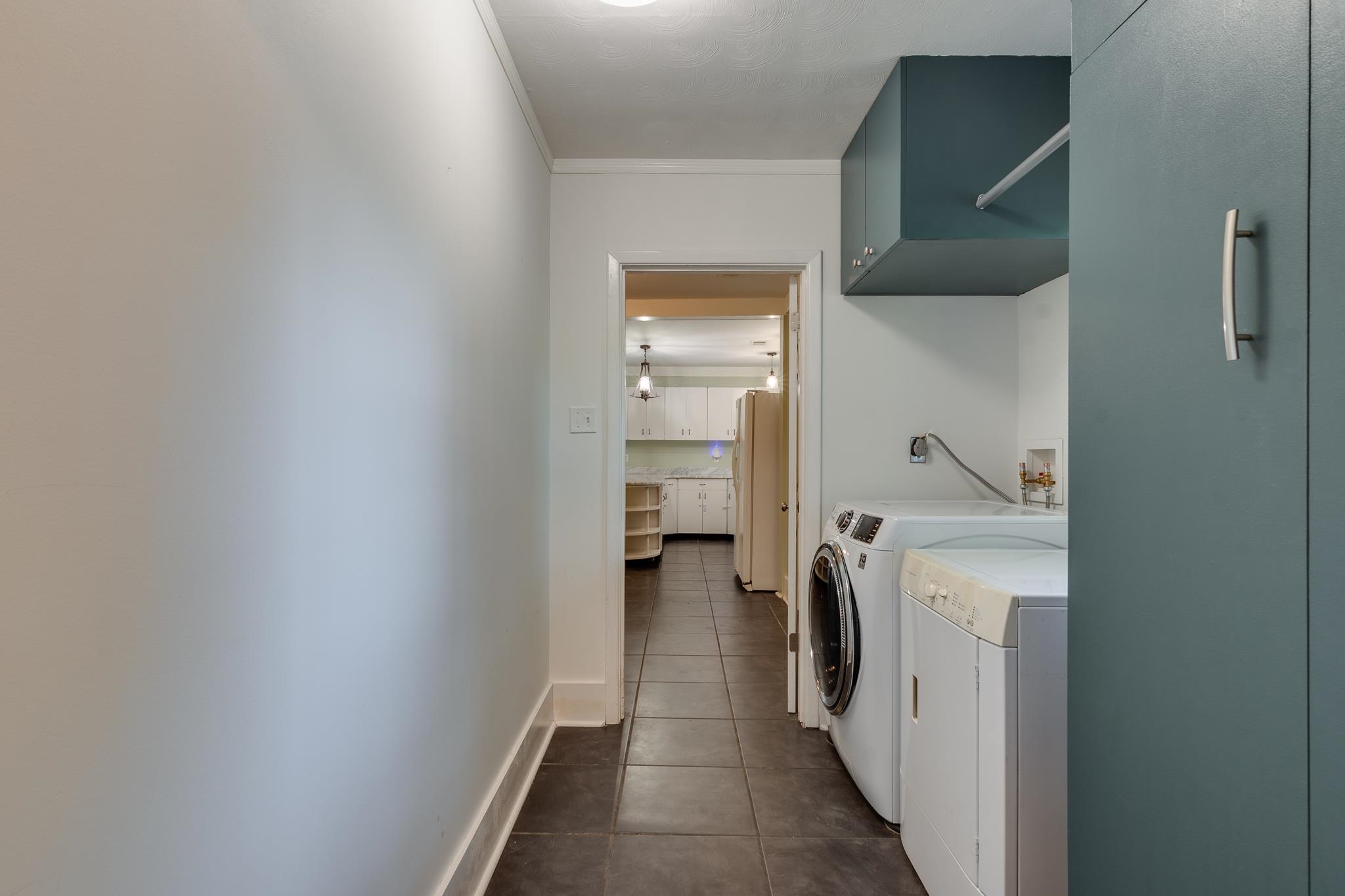 524 Alexander Street Memphis, TN 38111 - Photo 30 of 34 Laundry area with ornamental molding, independent washer and dryer, cabinets, and dark tile patterned floors