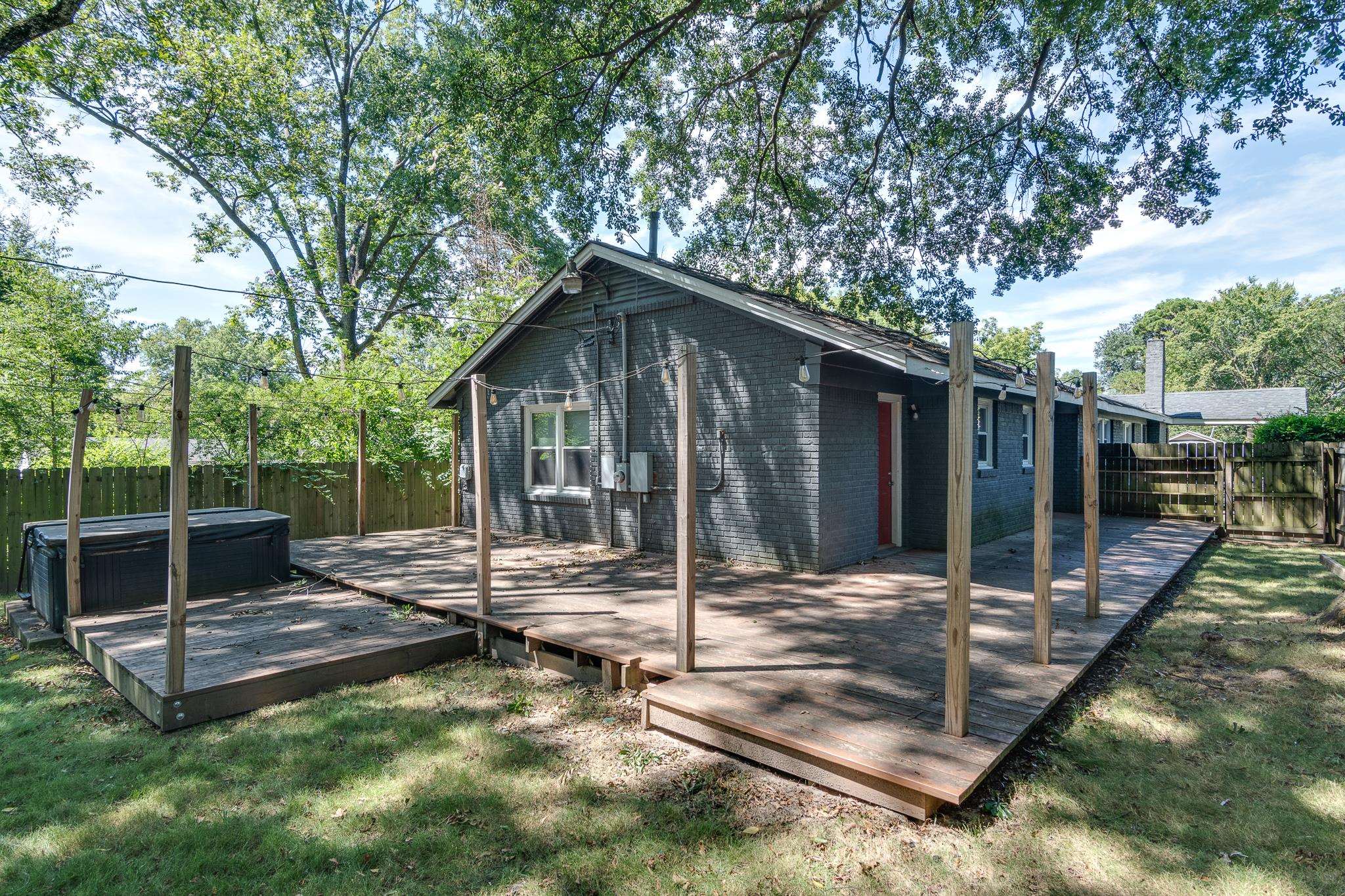 524 Alexander Street Memphis, TN 38111 - Photo 31 of 34 Exterior space featuring a lawn, a wooden deck, and a hot tub