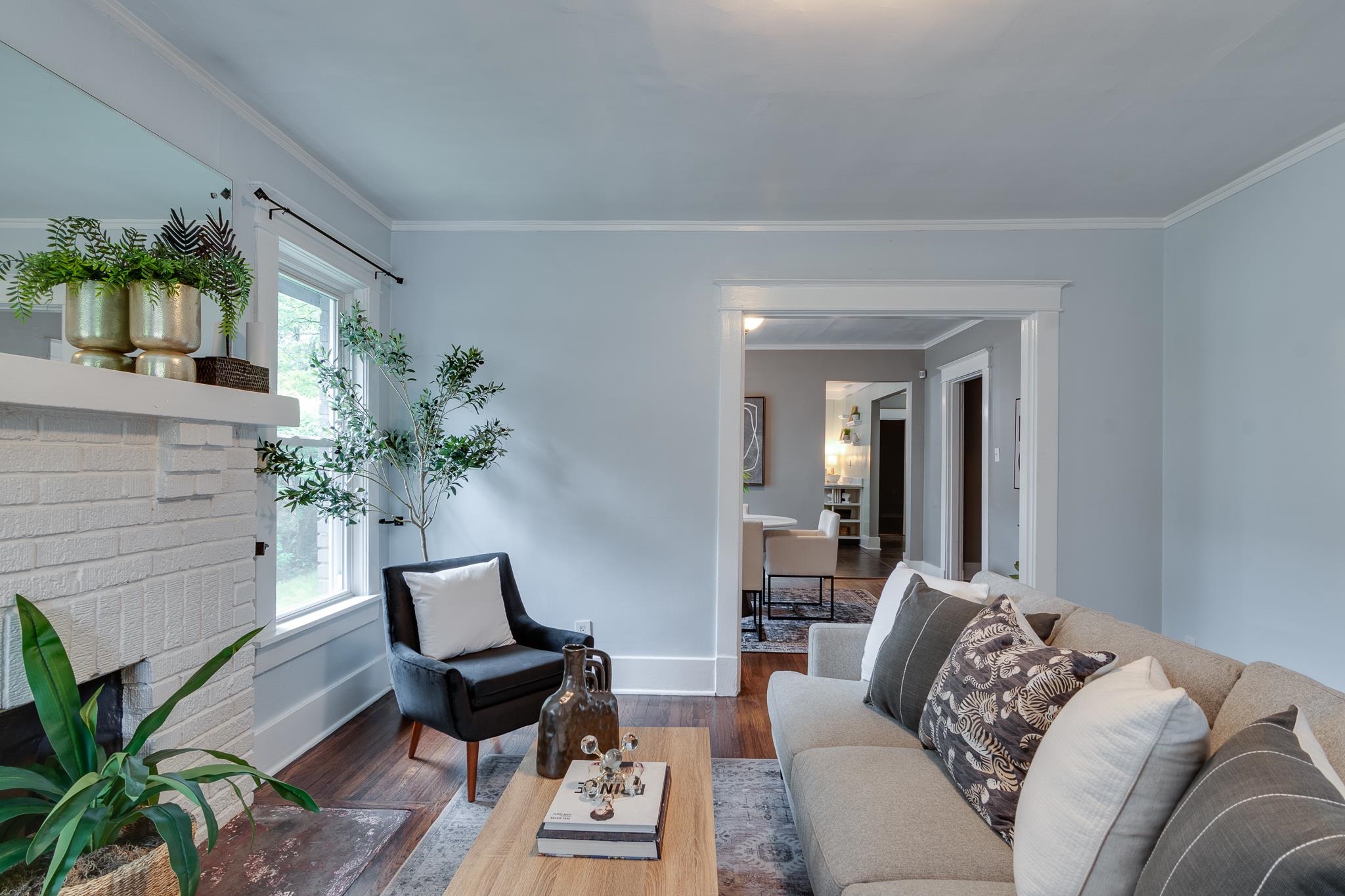 524 Alexander Street Memphis, TN 38111 - Photo 5 of 34 Living room featuring a wealth of natural light, ornamental molding, wood-type flooring, and a brick fireplace