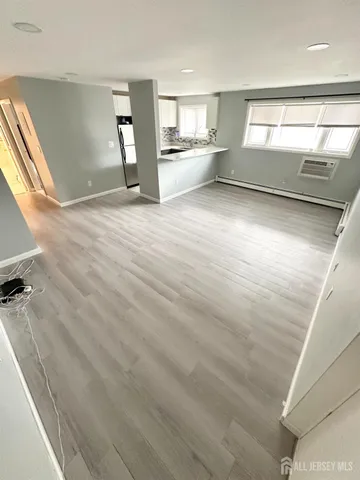 a view of a big room with wooden floor and windows