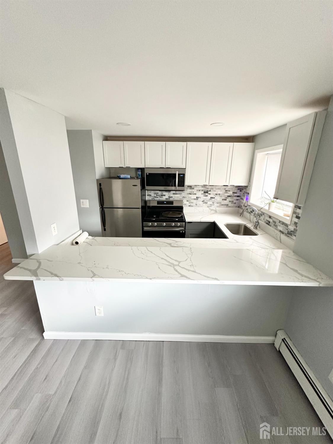 1604 74th Street, Unit B4 North Bergen, NJ 07047 - Photo 3 of 15 a living room with a couch and a table