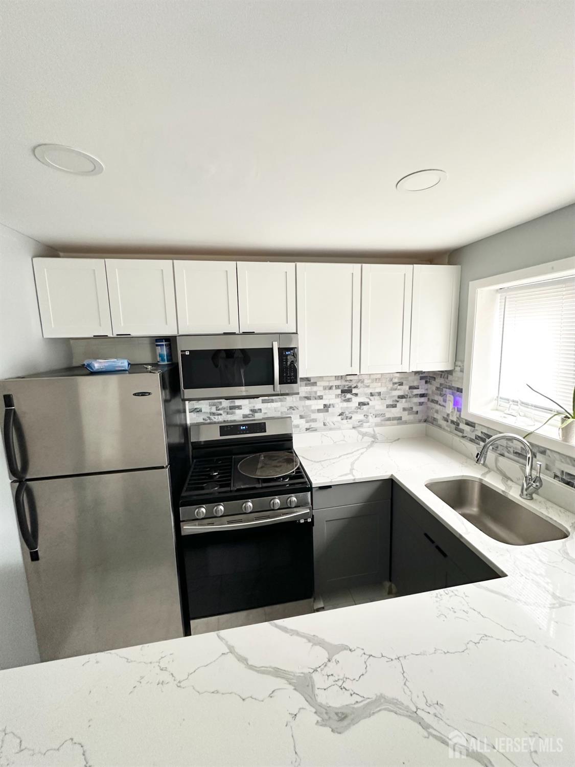 1604 74th Street, Unit B4 North Bergen, NJ 07047 - Photo 4 of 15 a kitchen with stainless steel appliances granite countertop a refrigerator a sink and a stove