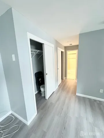 an empty room with wooden floor and closet