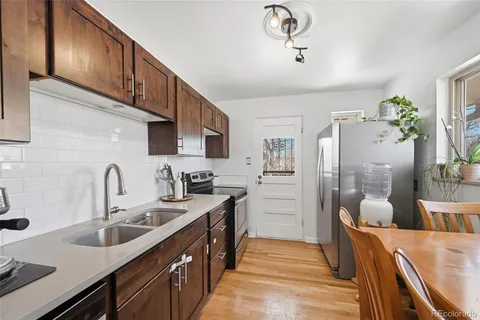 a kitchen with stainless steel appliances granite countertop a sink refrigerator and cabinets
