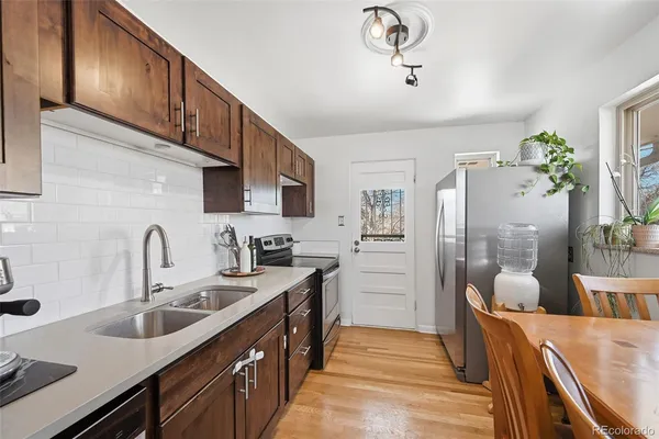 a kitchen with stainless steel appliances granite countertop a sink refrigerator and cabinets
