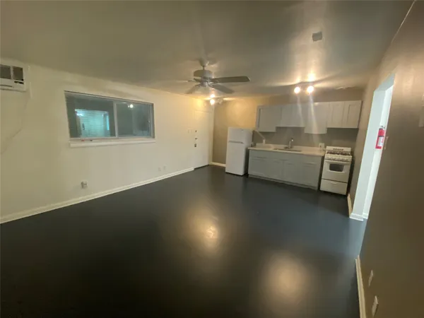 a view of a livingroom with furniture wooden floor and a ceiling fan