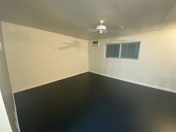 a view of a livingroom with wooden floor and a ceiling fan