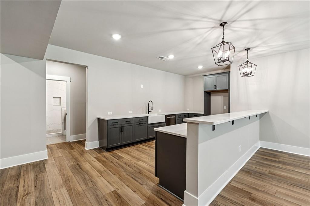 6326 Point Twenty Two Gainesville, GA 30506 - Photo 51 of 92 a large kitchen with stainless steel appliances a large counter top a stove and a wooden floors