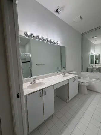 an empty room with windows and ceiling fan