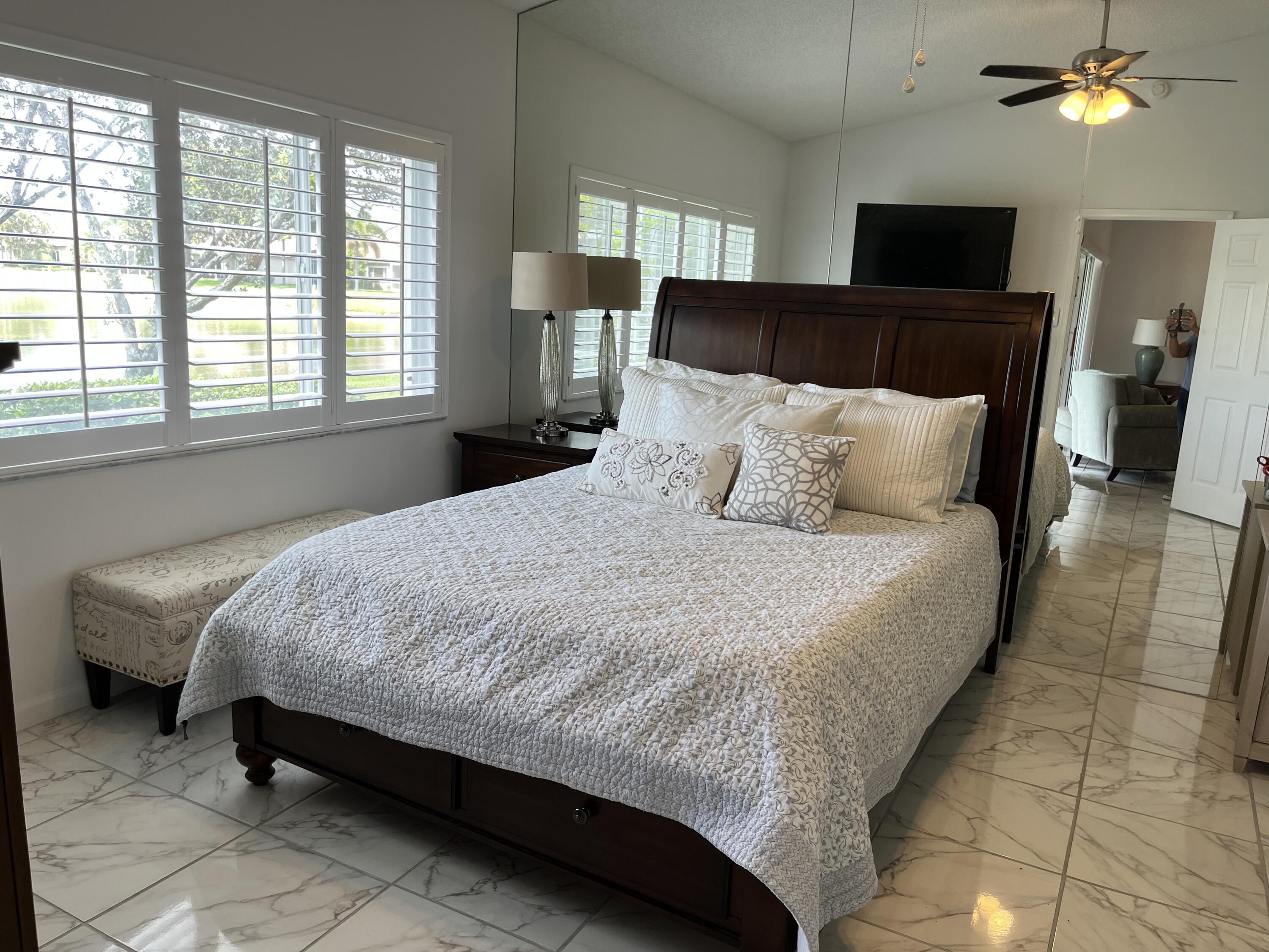 21105 Vía Solano Boca Raton, FL 33433 - Photo 8 of 14 a large bed sitting in a bedroom next to a lamp