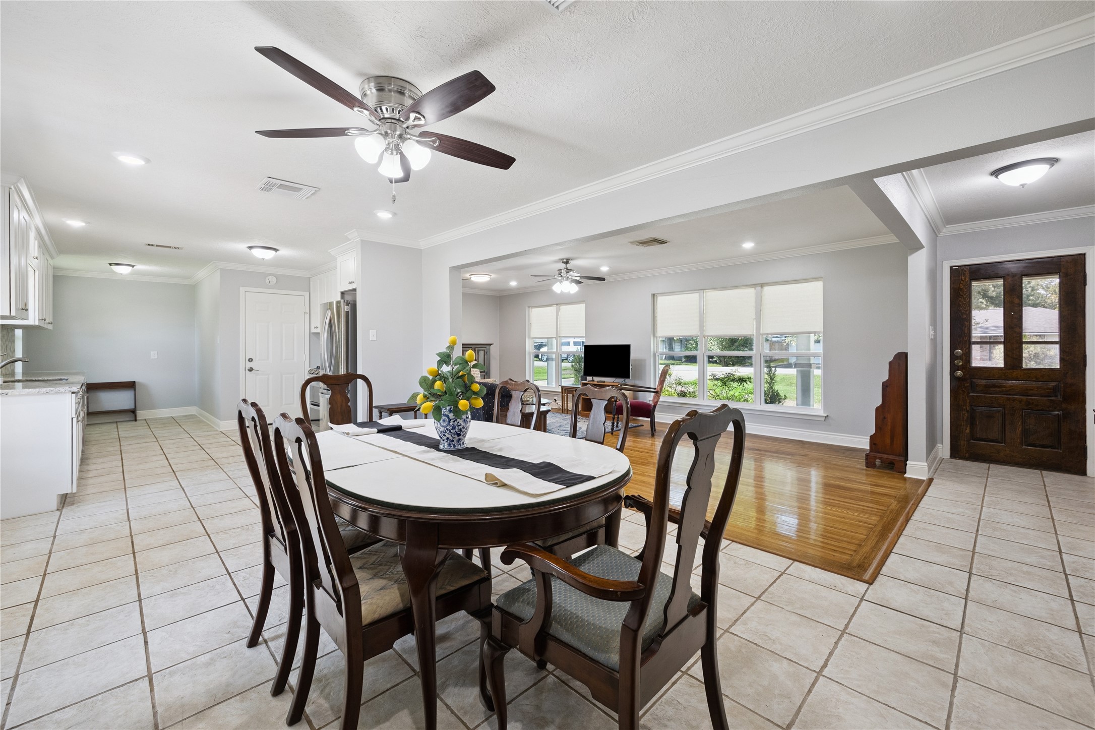 8911 Blankenship Drive Houston, TX 77080 - Photo 5 of 21 Experience the charm of this spacious open-concept living area, perfectly designed for both relaxation and entertaining. The dining room flows effortlessly into the kitchen, which boasts modern stainless steel appliances and ample cabinet space, elegant granite countertops, and soft-close cabinets. Abundant natural light pours in through large windows, enhancing the beauty of the hardwood floors and tiled areas, creating a welcoming and inviting atmosphere that you'll love coming home to.