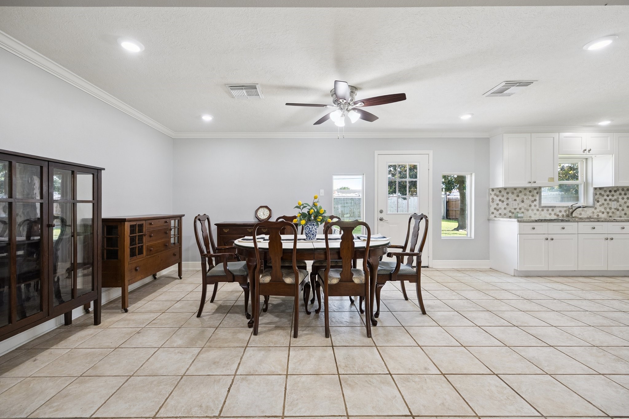 8911 Blankenship Drive Houston, TX 77080 - Photo 6 of 21 Imagine hosting gatherings in your spacious formal dining room, where tile flooring complements the abundant natural light. This inviting space flows effortlessly into a modern kitchen, adorned with sleek white cabinetry and a stylish backsplash. It’s the perfect setup for entertaining guests, ensuring everyone feels comfortable. You’ll love the seamless connection between these areas, making every occasion special.