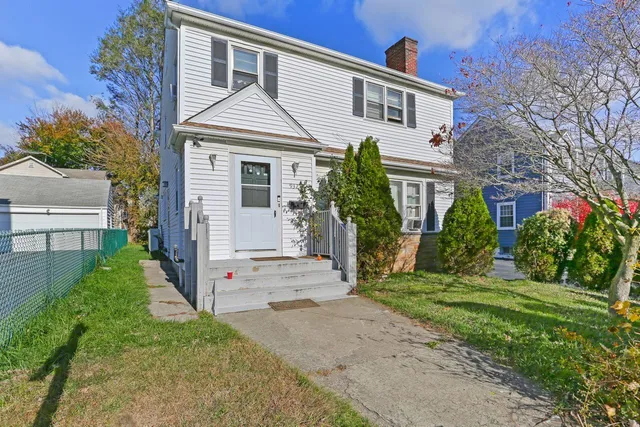 a front view of a house with a yard and potted plants