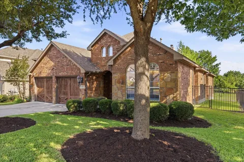 a front view of a house with a yard and potted plants