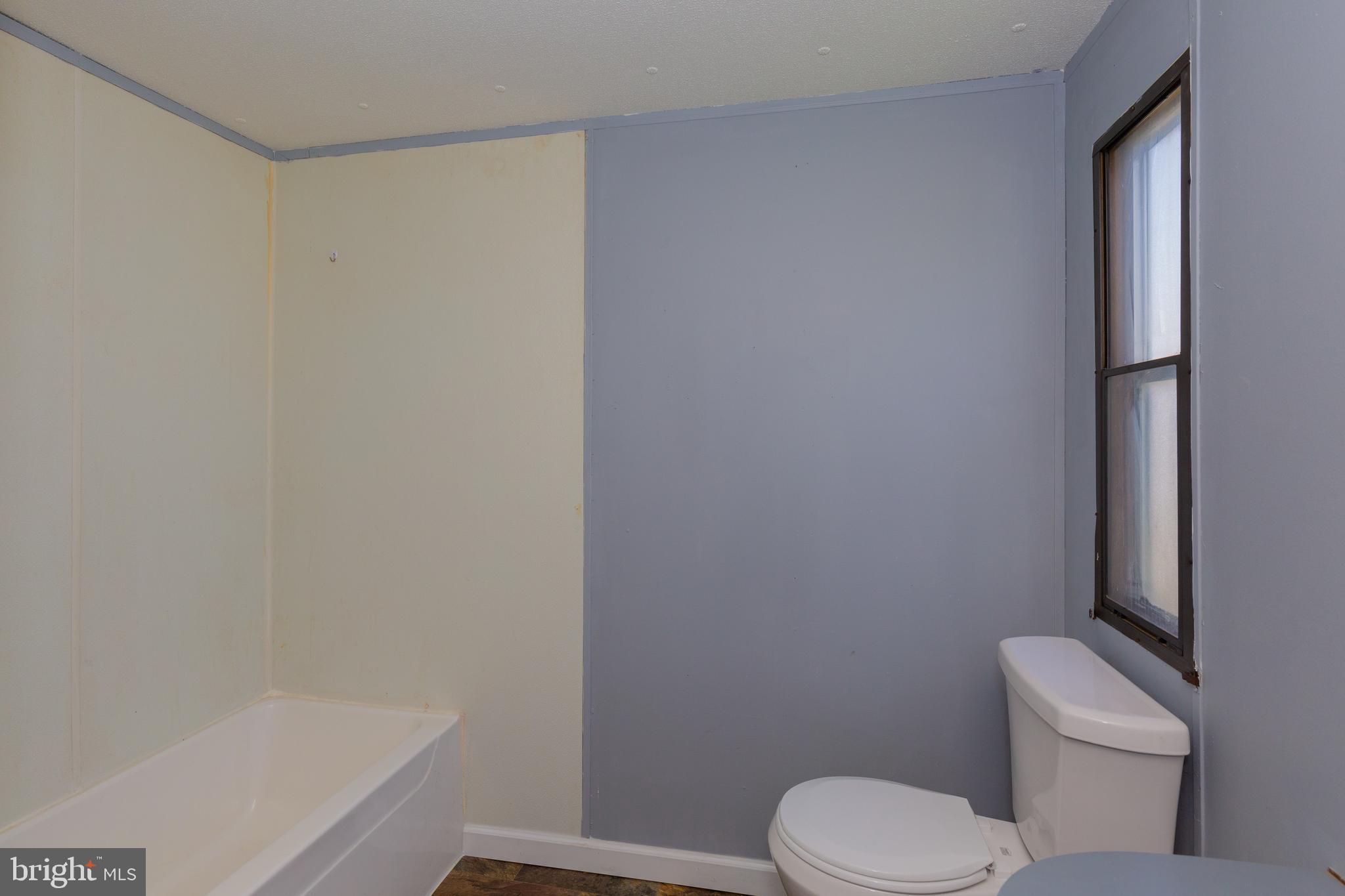 90 Fabric Drive Bunker Hill, WV 25413 - Photo 13 of 28 a white toilet sitting next to a bath tub