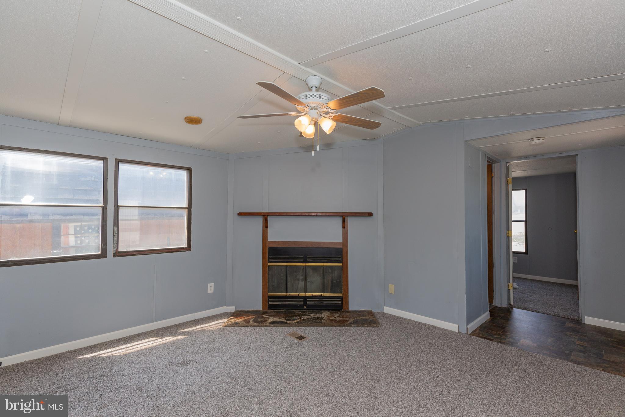 90 Fabric Drive Bunker Hill, WV 25413 - Photo 22 of 28 an empty room with chandelier fan and windows