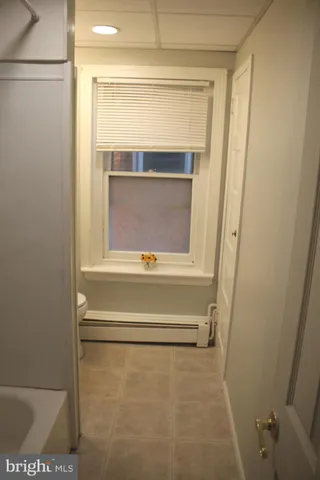 a view of a front of a house with a yard plants and a large tree