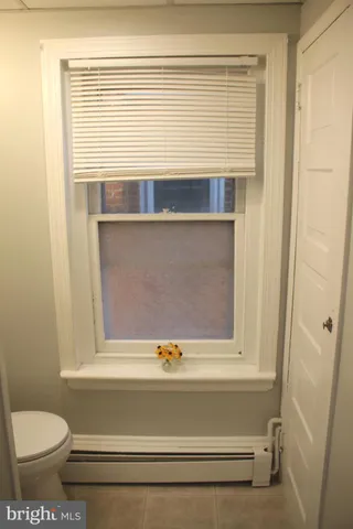 a view of a front of a house with a yard plants and a large tree